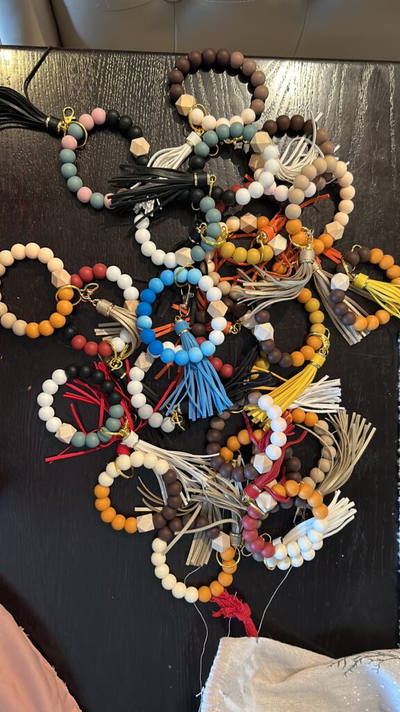 Dozens of colourful silicone beaded key chains with tassels, made by our members
